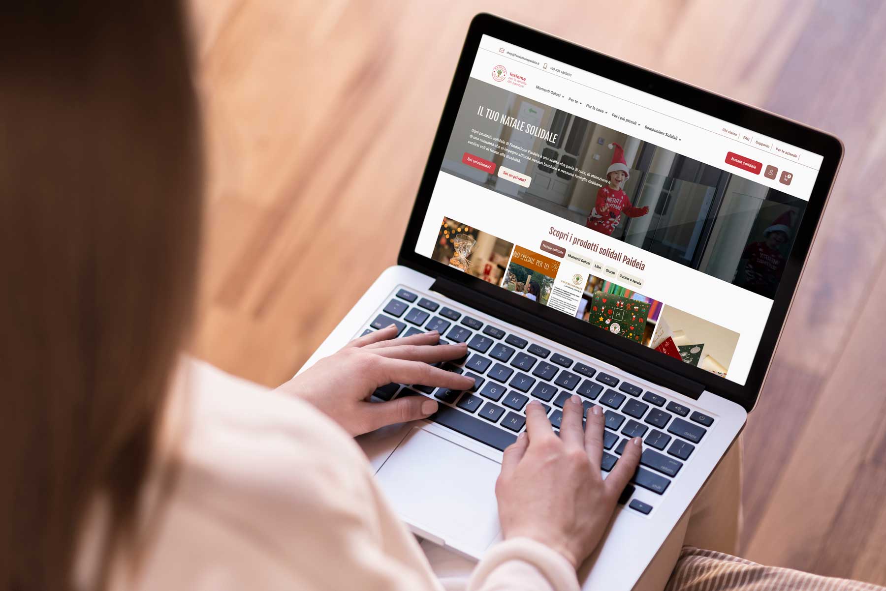 immagine di una persona con un laptop davanti che mostra la homepage dello shop di Paideia